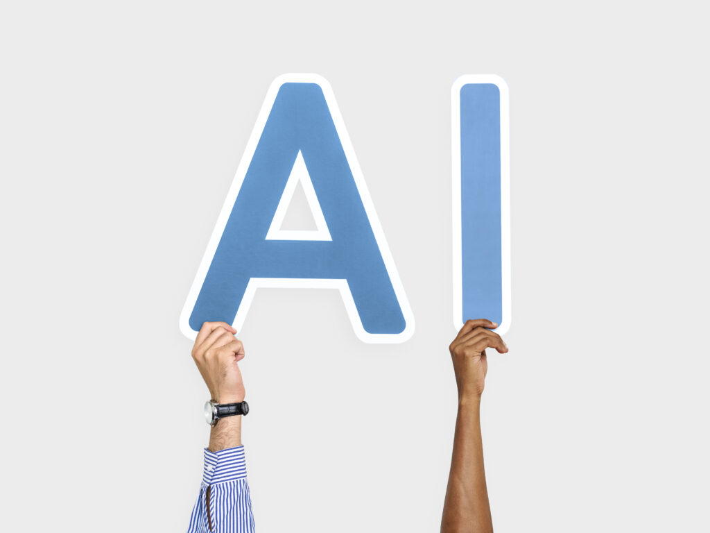Hands holding up blue letters forming the abbreviation AI